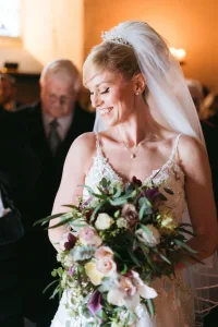 A bride with a beautiful smile walks down the aisle at Orchardleigh House, captured in stunning photos.