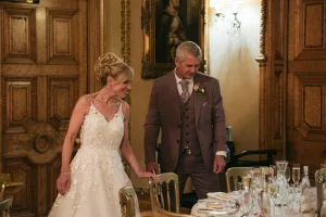 A bride and groom standing at a table in Orchardleigh House.