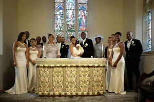 wedding photography A wedding party posing in front of a stained glass window for Orchardleigh Wedding Photography.