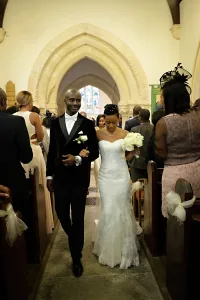 wedding photography Orchardleigh Wedding Photography captures the joyful moment of a bride and groom elegantly walking down the aisle of a church.