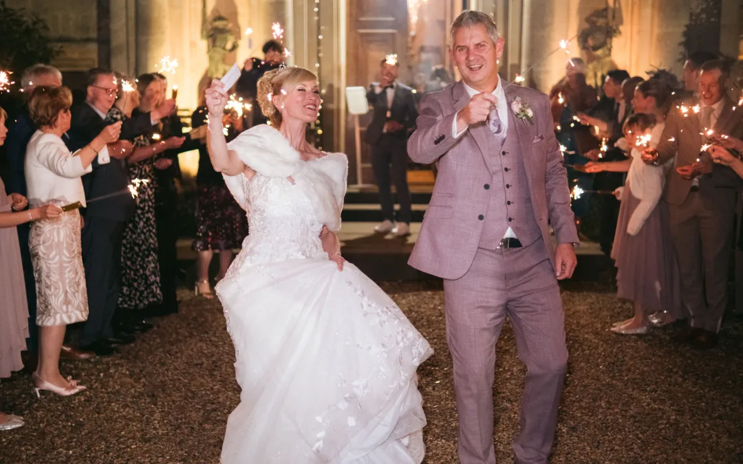 A bride and groom at Orchardleigh House, joyfully holding sparklers in their hands.