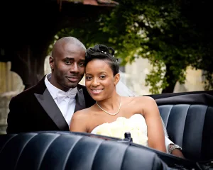 A newlywed couple posing in a black car captured by their wedding photographer in Bath.