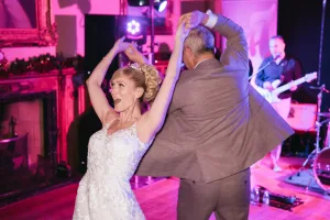 A couple joyfully dances at their wedding reception, captured in enchanting Orchardleigh House photos.