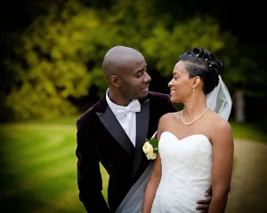 A bride and groom standing together in a park, captured beautifully by a Bath Wedding Photographer.