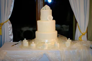 wedding photography A wedding photographer capturing a stunning white wedding cake on a table at the scenic Orchardleigh estate.
