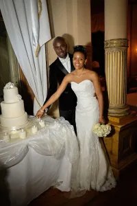 wedding photography A bride and groom standing in front of a wedding cake captured by the Wedding Photographer at Orchardleigh.