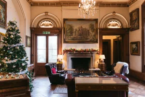 A cozy living room adorned with a crackling fireplace and a beautifully decorated Christmas tree.