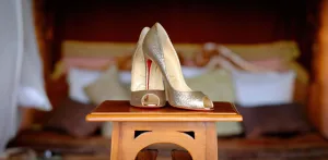 wedding photography Christian Louboutin wedding shoes on a wooden table at Orchardleigh House.