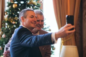 Two men taking a selfie in front of Orchardleigh House's Christmas tree.