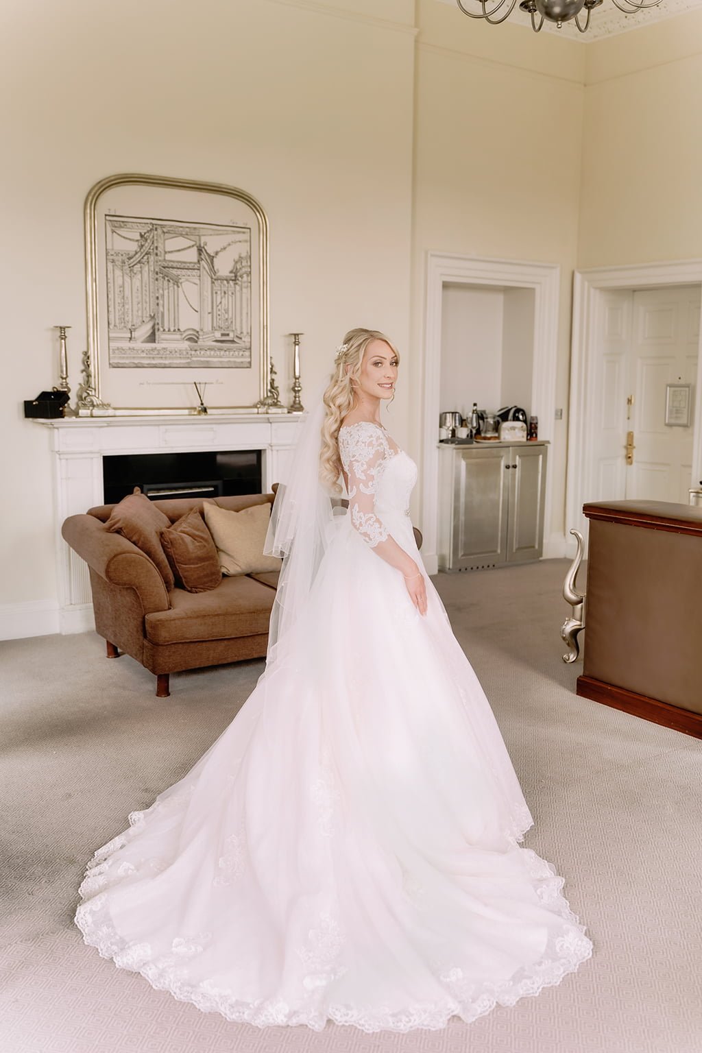 a woman in a wedding dress standing in a living room.
