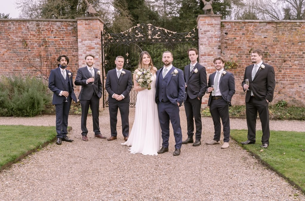 a group of people standing in front of a brick wall.