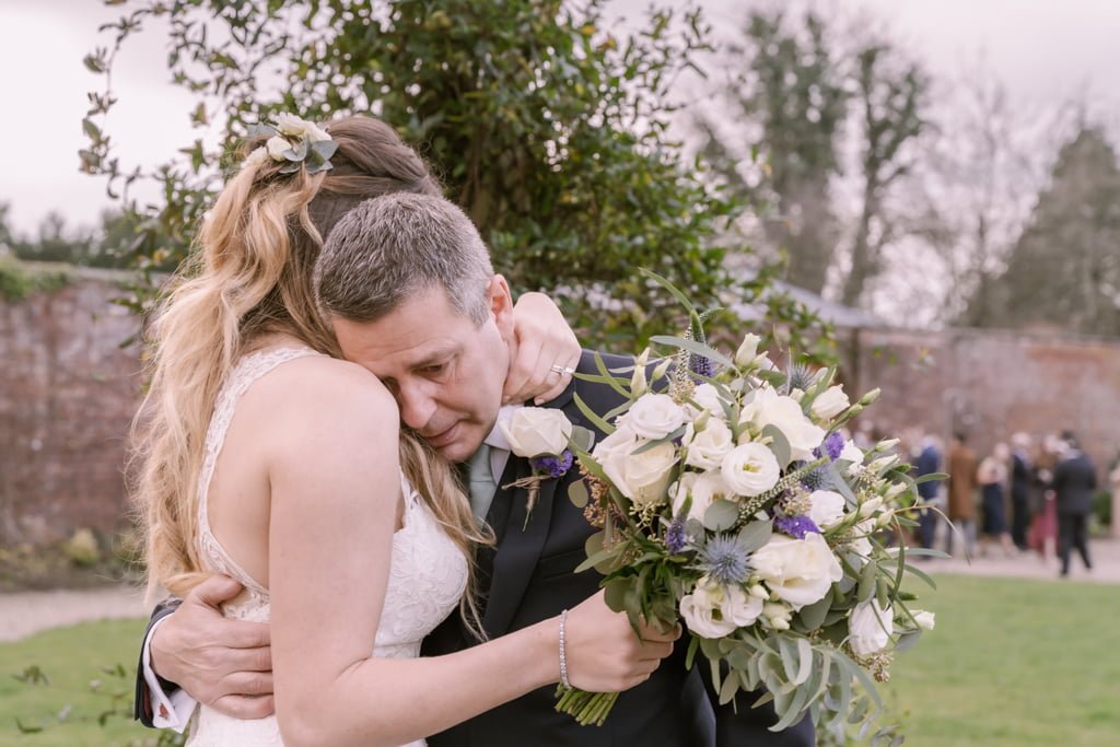 a bride and groom hugging each other in a park on the Orchardleigh Estate Frome