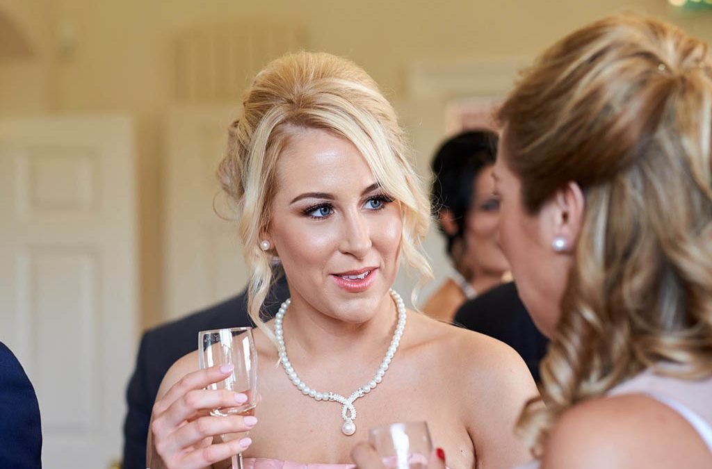a woman in a wedding dress holding a glass of wine.