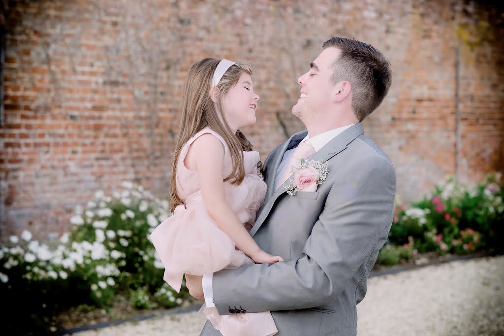 a man in a suit and a little girl in a pink dress.
