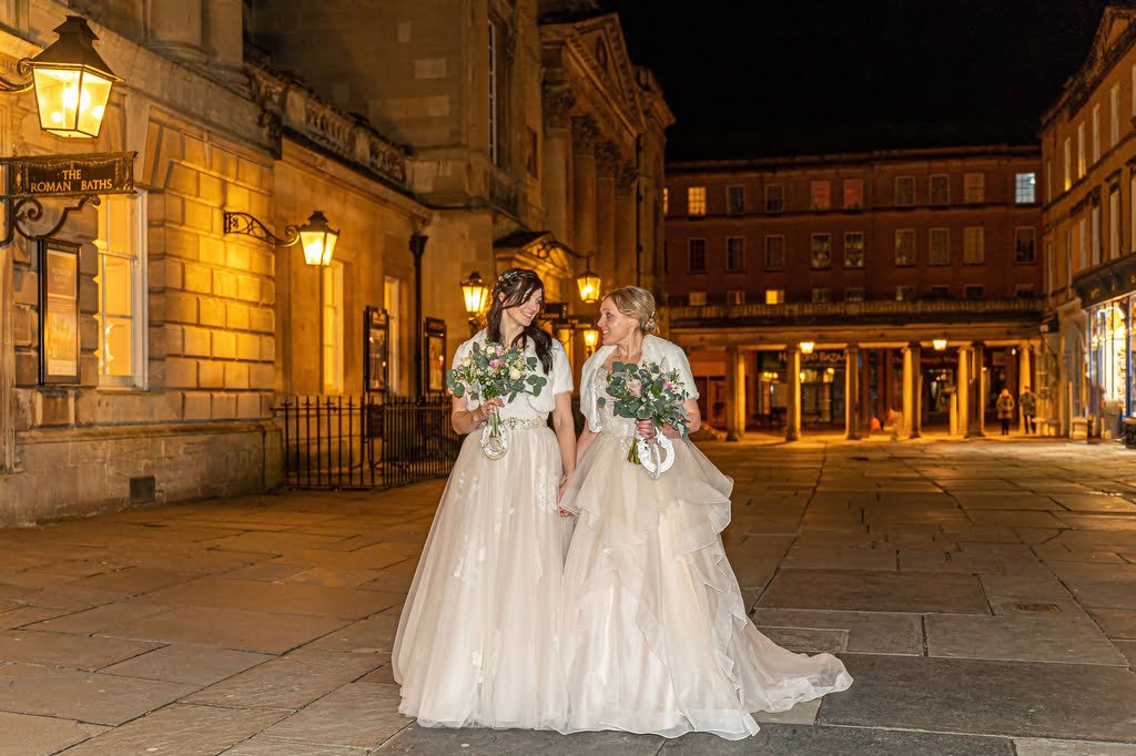 Lesbian Wedding in Bath: a couple of women standing next to each other on a street.