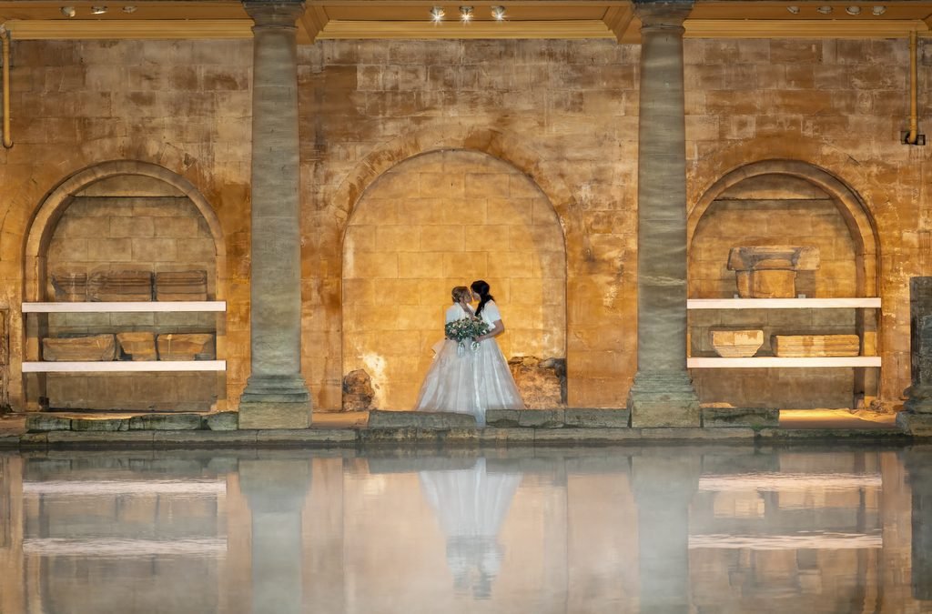 Gay weddings Roman Baths: a woman in a wedding dress standing next to a pool.
