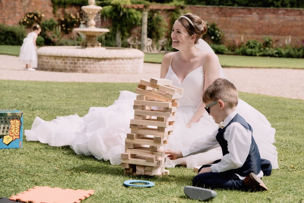 a bride and her son playing with a tower game.