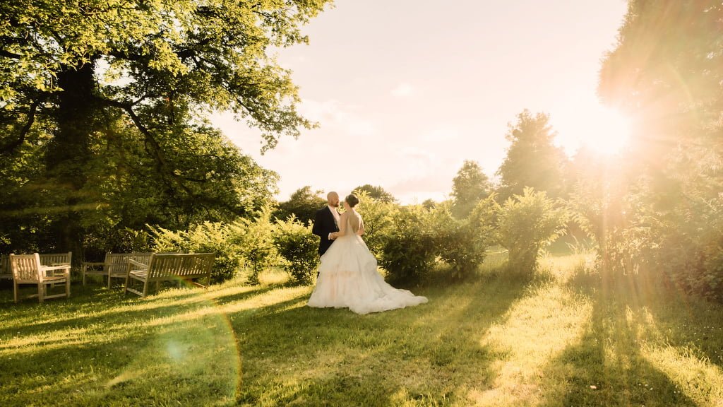 a bride and groom are standing in the grass.
