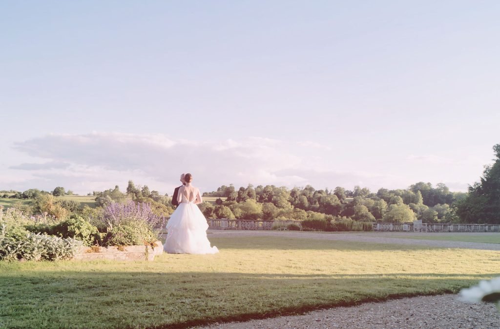 a woman in a wedding dress standing in a field.