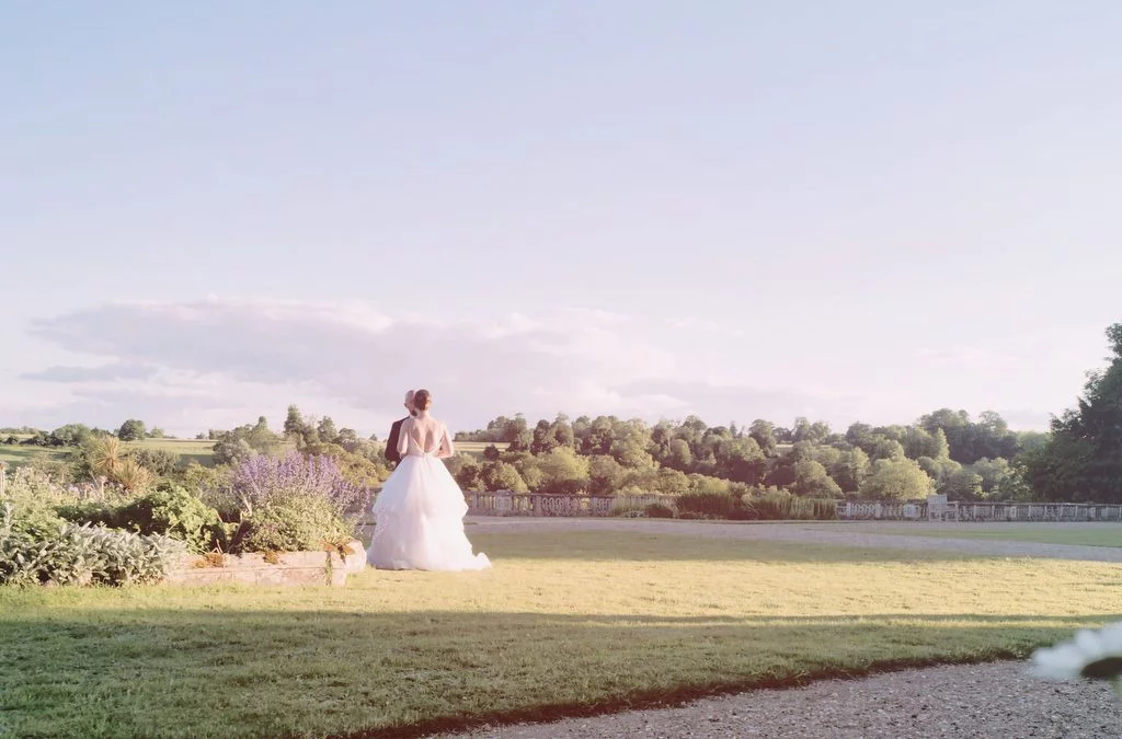 a woman in a wedding dress standing in a field.