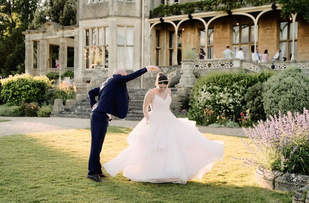a bride and groom dancing in front of a castle.
