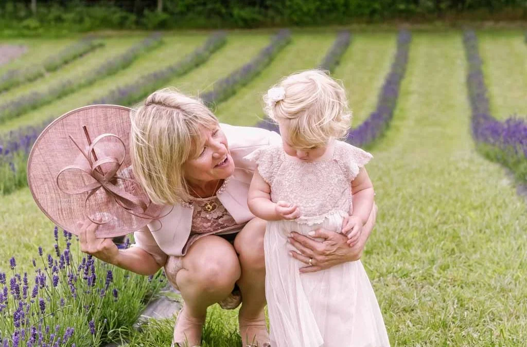 a woman holding a little girl in a field.