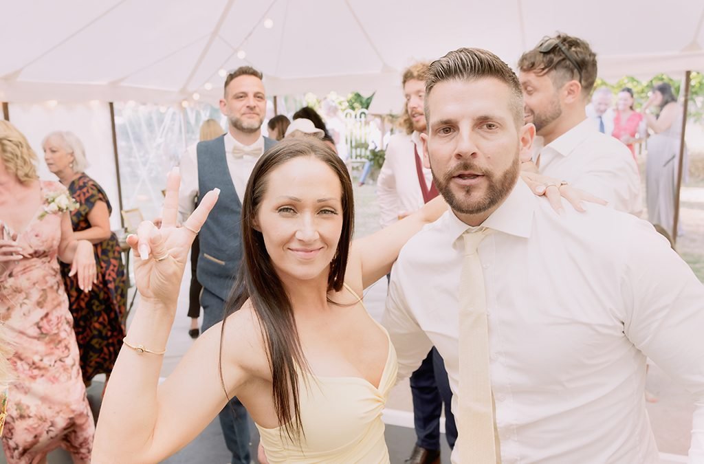 Wedding guests dancing and looking at the camera