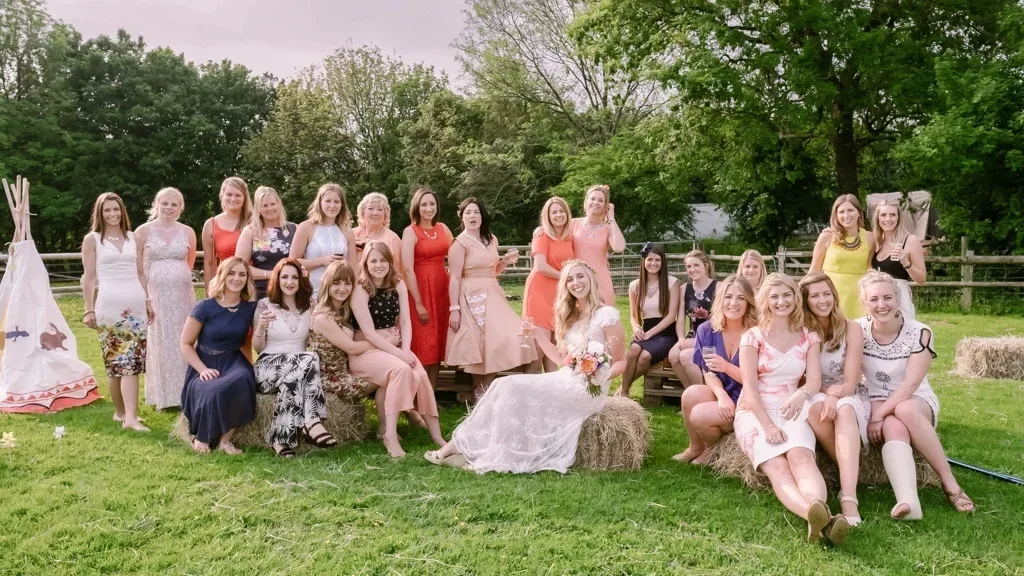 Rustic Weddings:a group of women sitting on top of a lush green field.