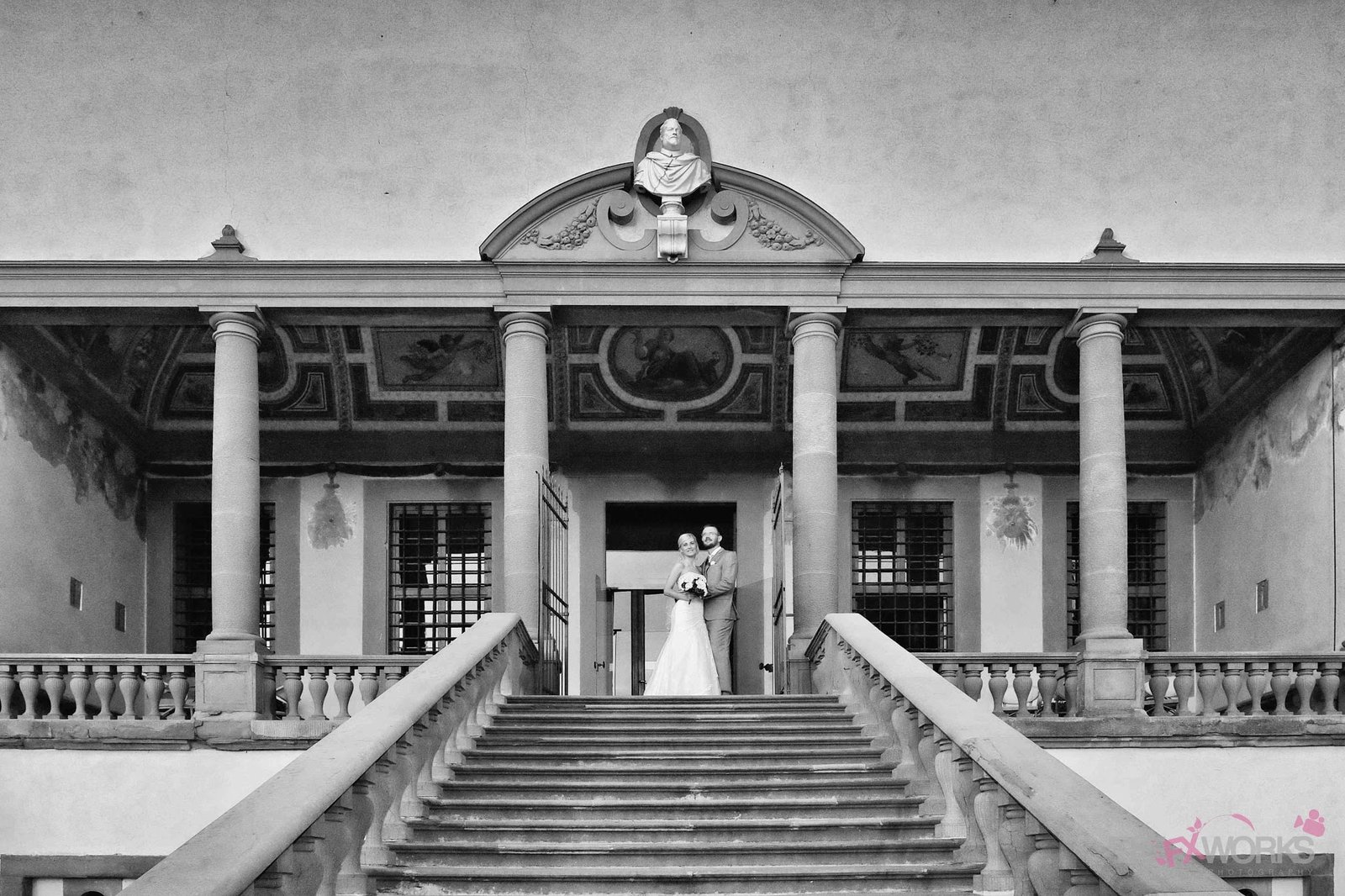 a bride and groom standing on the steps of a building.
