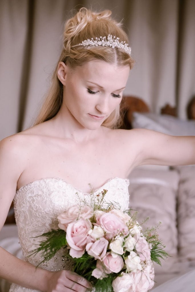 a woman in a wedding dress holding a bouquet of flowers.