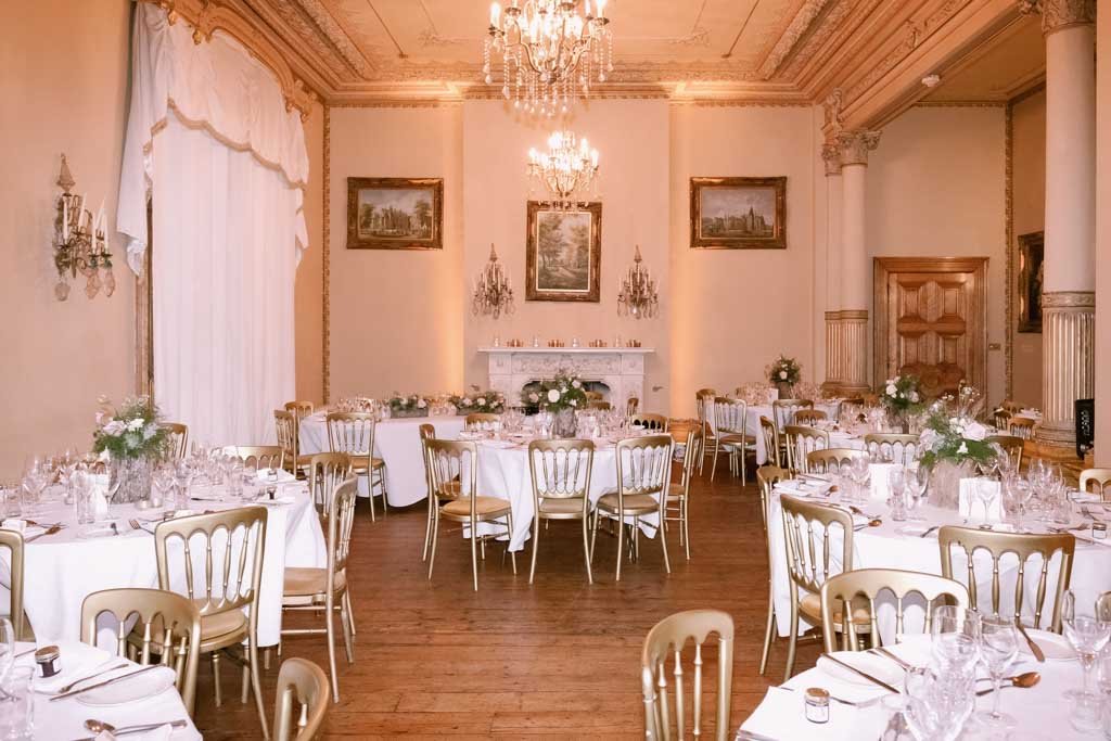 a room filled with tables and chairs covered in white tablecloths.