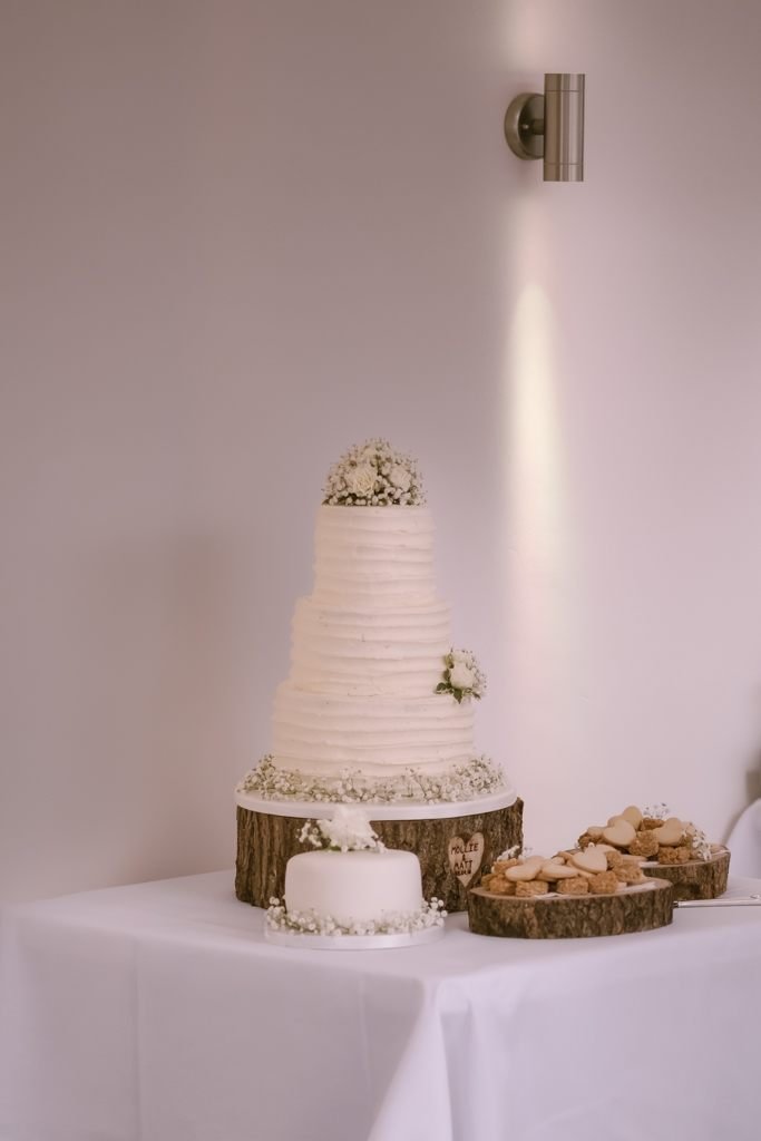 a wedding cake and cookies on a table.