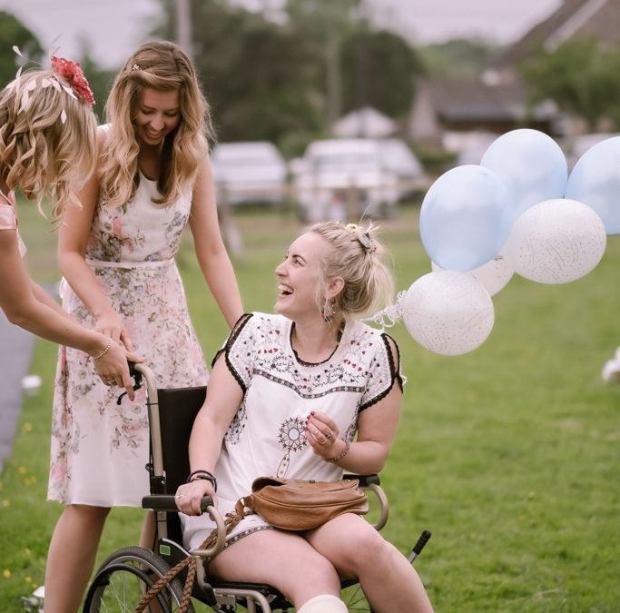 a woman in a wheel chair being pushed by another woman.