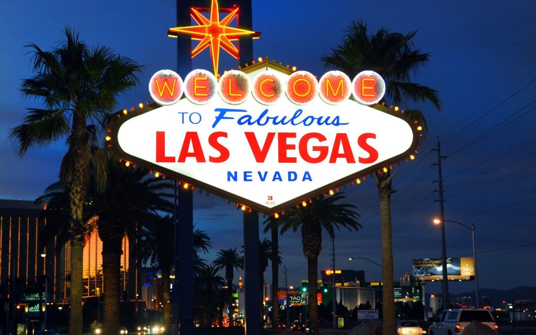 a large welcome sign is lit up at night in Las Vegas