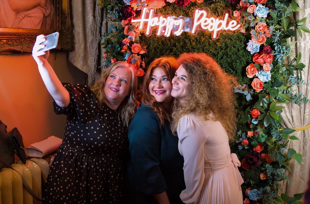 Girls taking a selfie at a wedding taken naturally