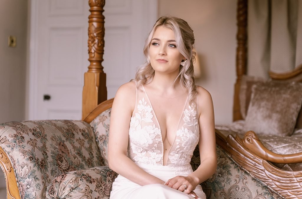 a woman in a wedding dress sitting on a couch.