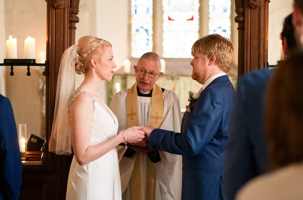 a man and a woman holding hands during a wedding ceremony.