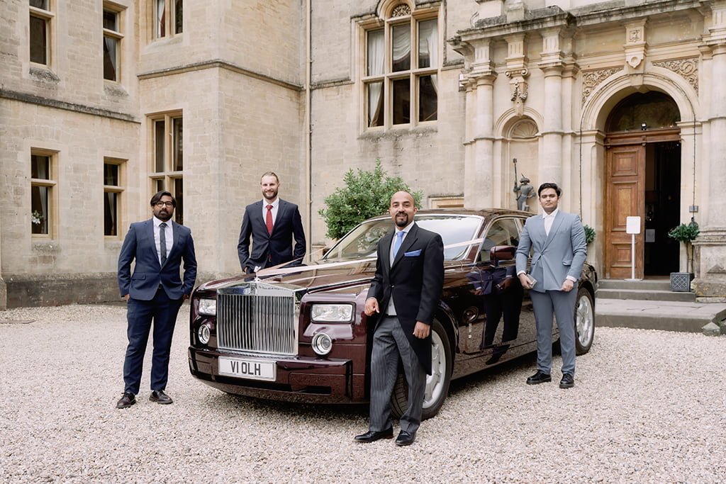 Wedding Group photo at Orchardleigh House:a group of men standing next to a car.
