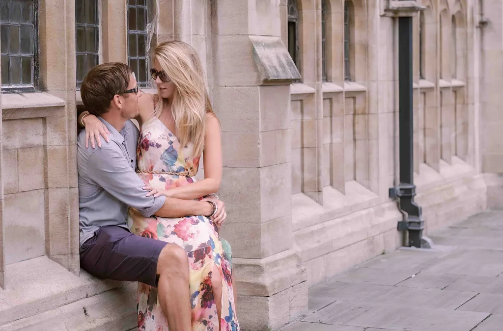 Michael Gane Bath Wedding Photographer: a man and a woman sitting on a ledge kissing.