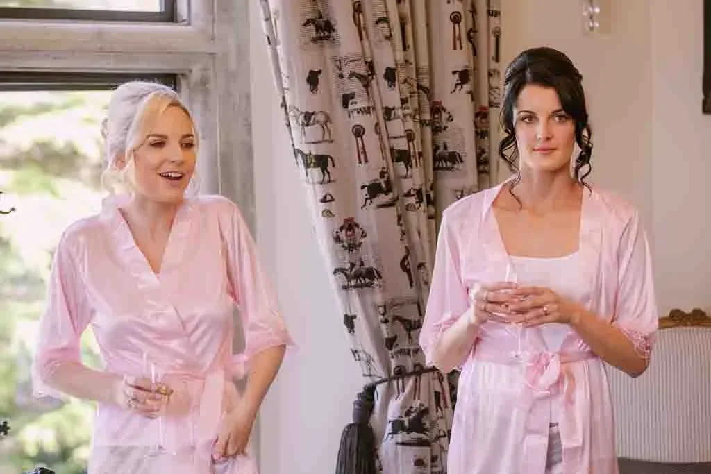 Check list: two women in pink robes standing next to each other by Bath Wedding Photographer
