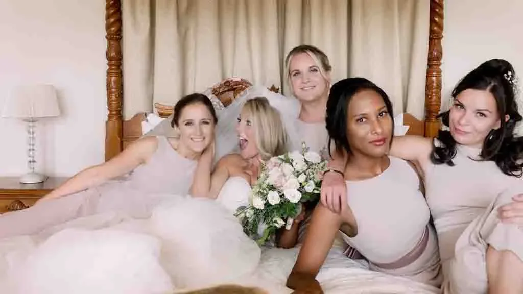 Wedding Photography Bath Guest List: a group of bridesmaids posing for a picture in a bed in the Bernita suit at Orchardleigh House