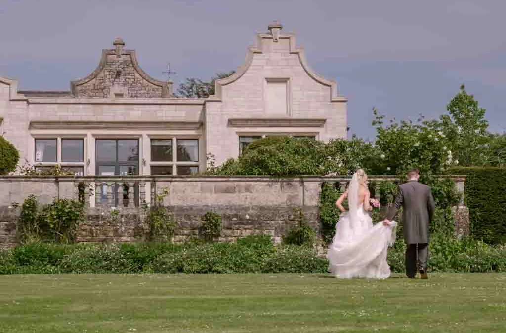 Top Wedding Venues: a bride and groom walking in front of a Old Down house Wedding Venue