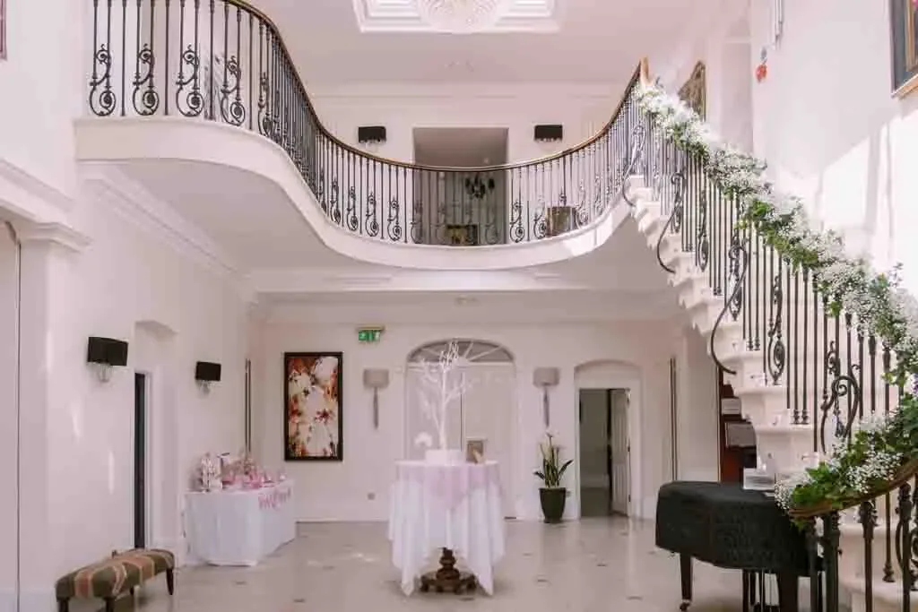 a white room with a staircase and a table.