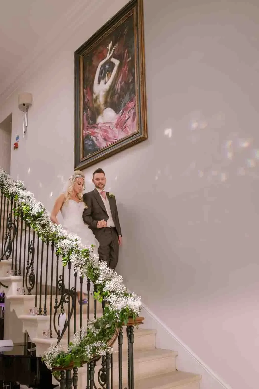 a bride and groom standing on a staircase.