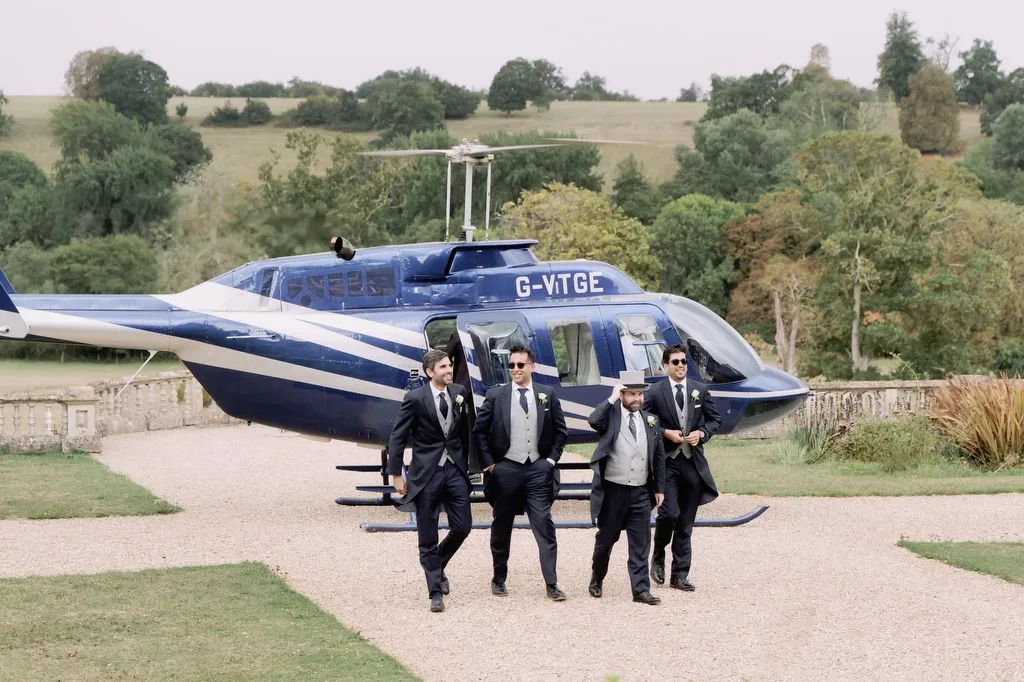 a group of men in suits standing in front of a helicopter.