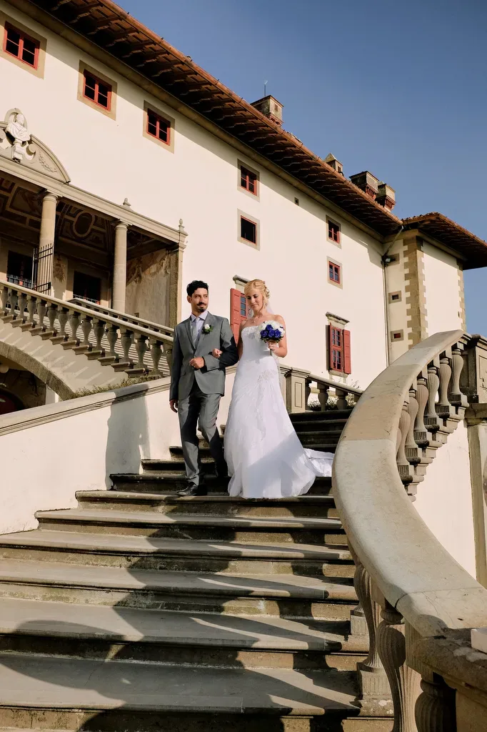 a bride and groom walking down a set of stairs.