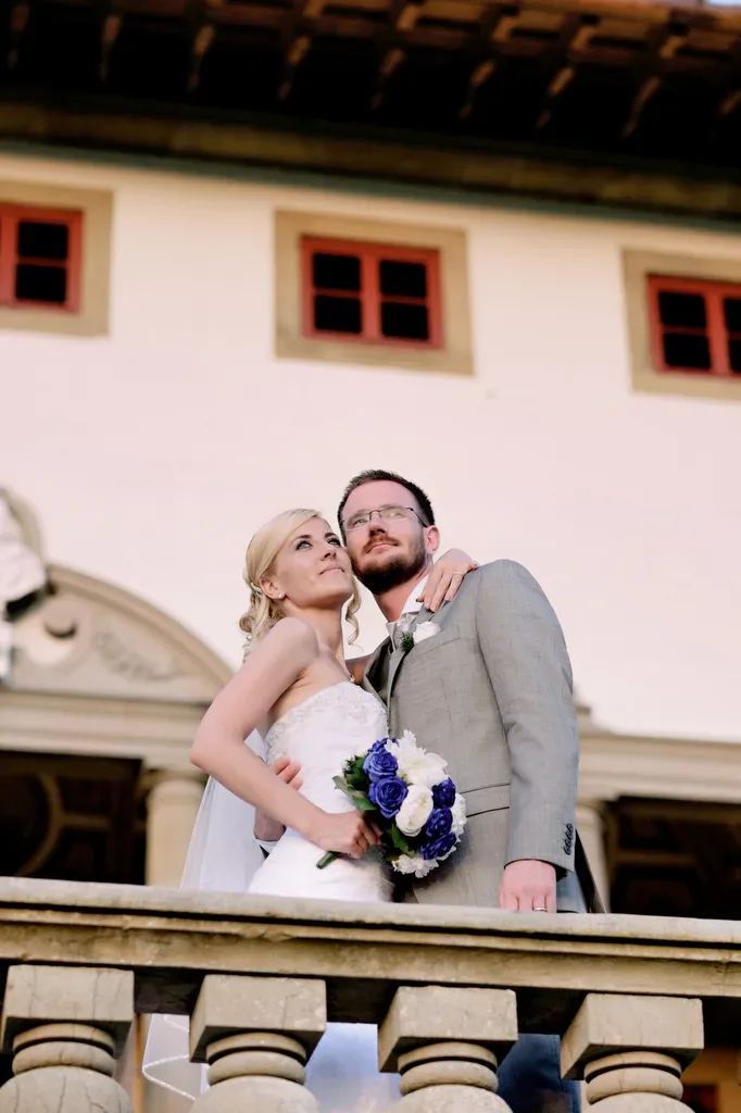 a bride and groom standing on a balcony.