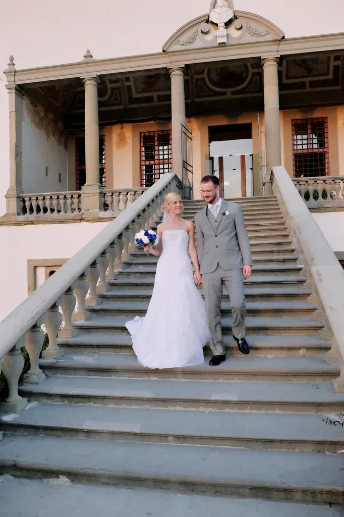 a bride and groom walking down a set of stairs.