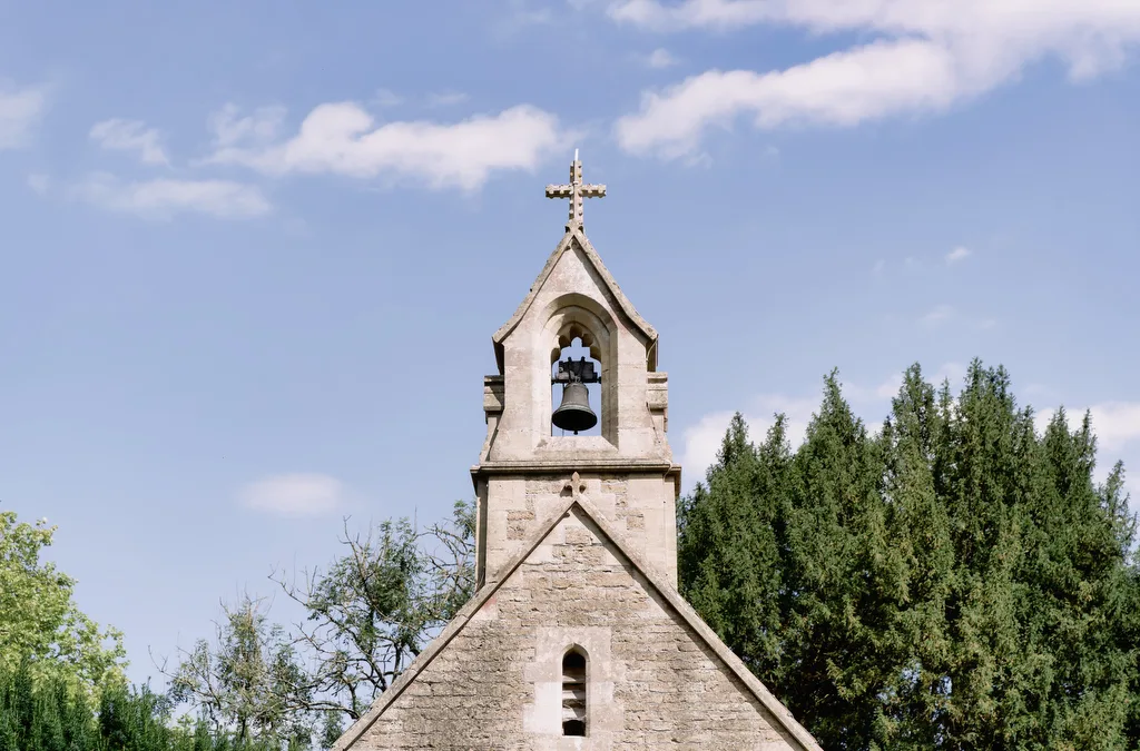 a church with a bell tower and a cross on top.
