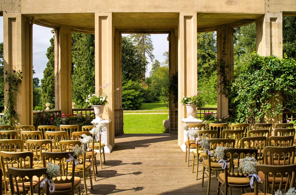 an outdoor ceremony setup with chairs and flowers.